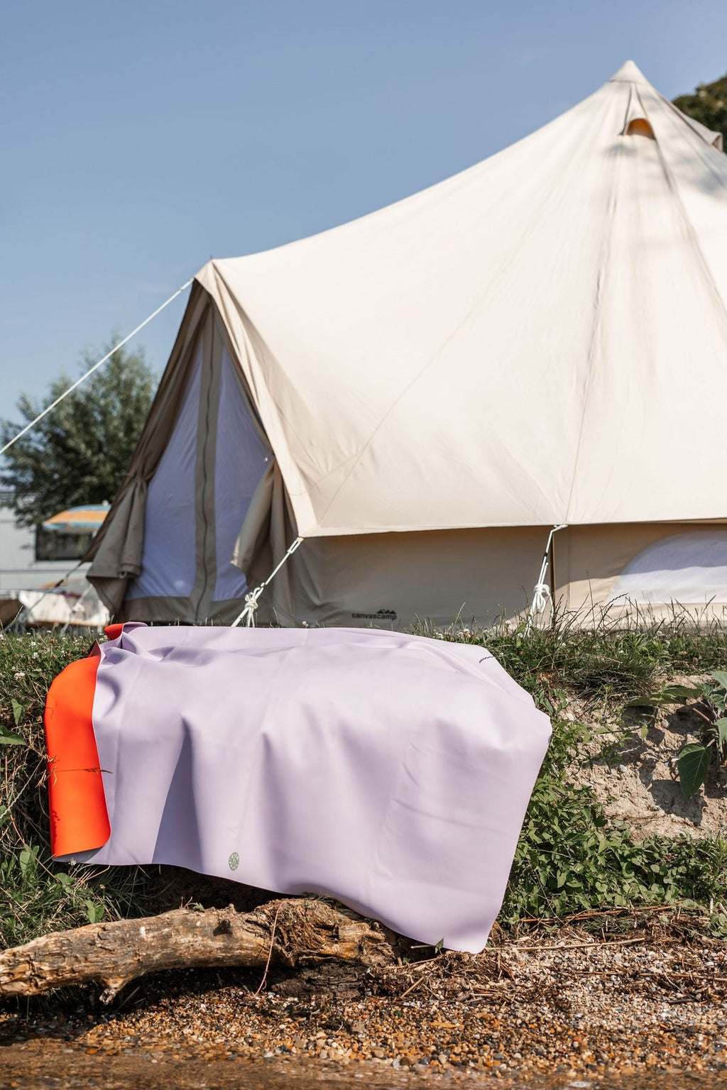 Lavender Studio Huske mat folded over driftwood at a coastal campsite with bell tent on pebble beach