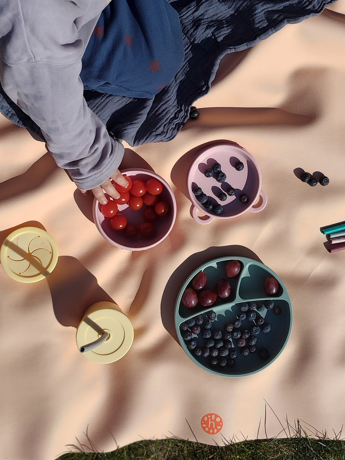 Studio Huske silicone play mat — Toddler boy at table using clay stamps on mustard yellow Roam Mat as craft surface, felt