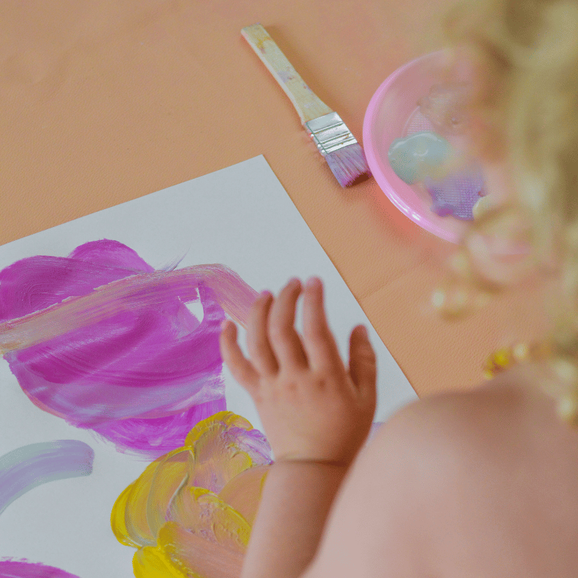 Toddler painting on the kitchen table on a rainy day using a studio huske roam crafting and activity