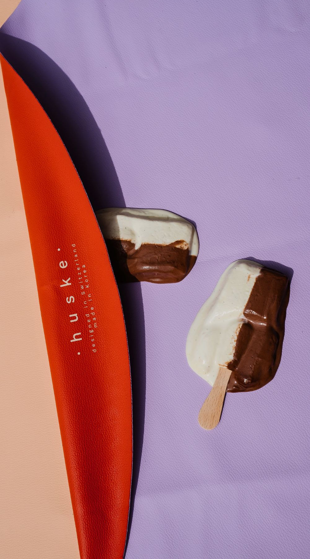 Folded silicone leather play mat in orange and lilac with ice-cream pops on surface, waterproof and easy to clean, Studio Huske.