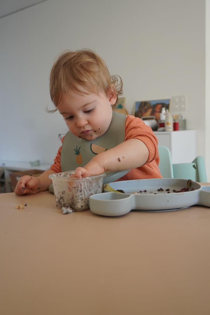 Baby-led weaning toddler with food on face, Studio Huske silicone mat on table 