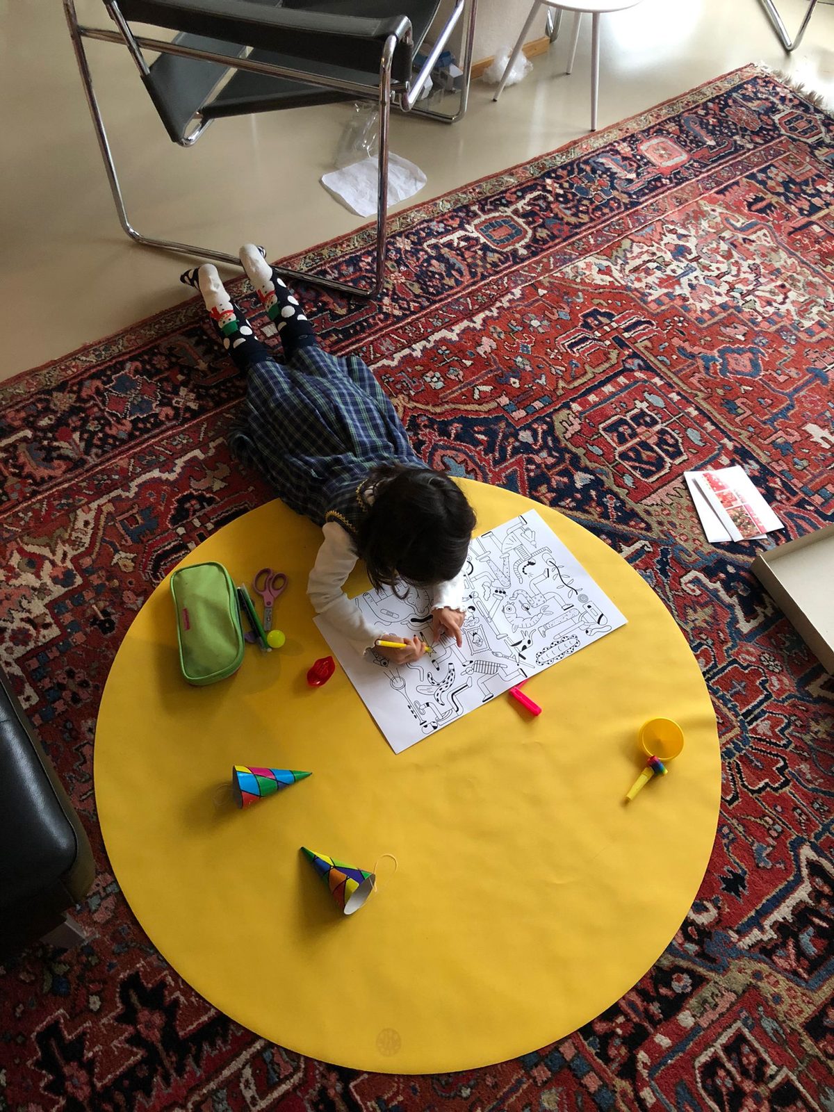 Child playing on yellow Huske Explore mat on Christmas morning surrounded by festive decorations