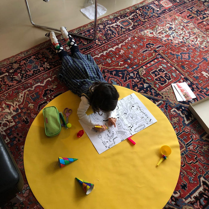 Child playing on yellow Huske Explore mat on Christmas morning surrounded by festive decorations