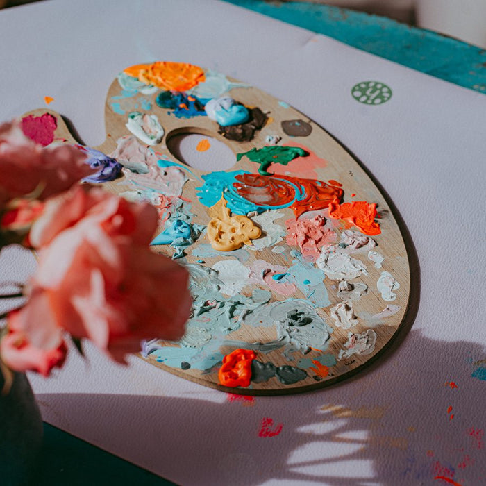 Child painting at a table on a Studio Huske Roam silicone leather mat used as a wipe clean craft surface