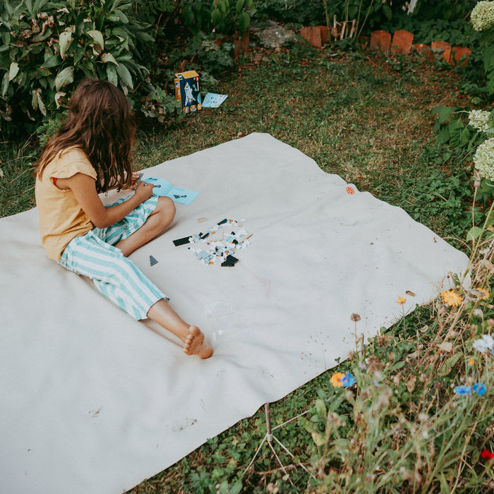 Kleines Mädchen baut Lego auf cremefarbener Studio Huske Spielmatte