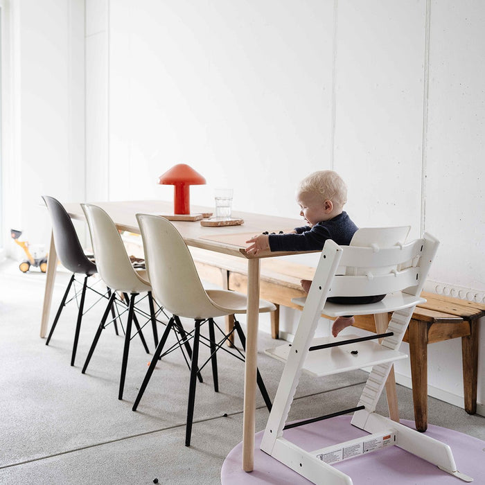Baby at high chair with Studio Huske silicone mat on the floor at the dining table