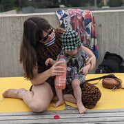 Explore Yellow/Mocca large round silicone play mat, adult and toddler sitting on the yellow mat with room to spare