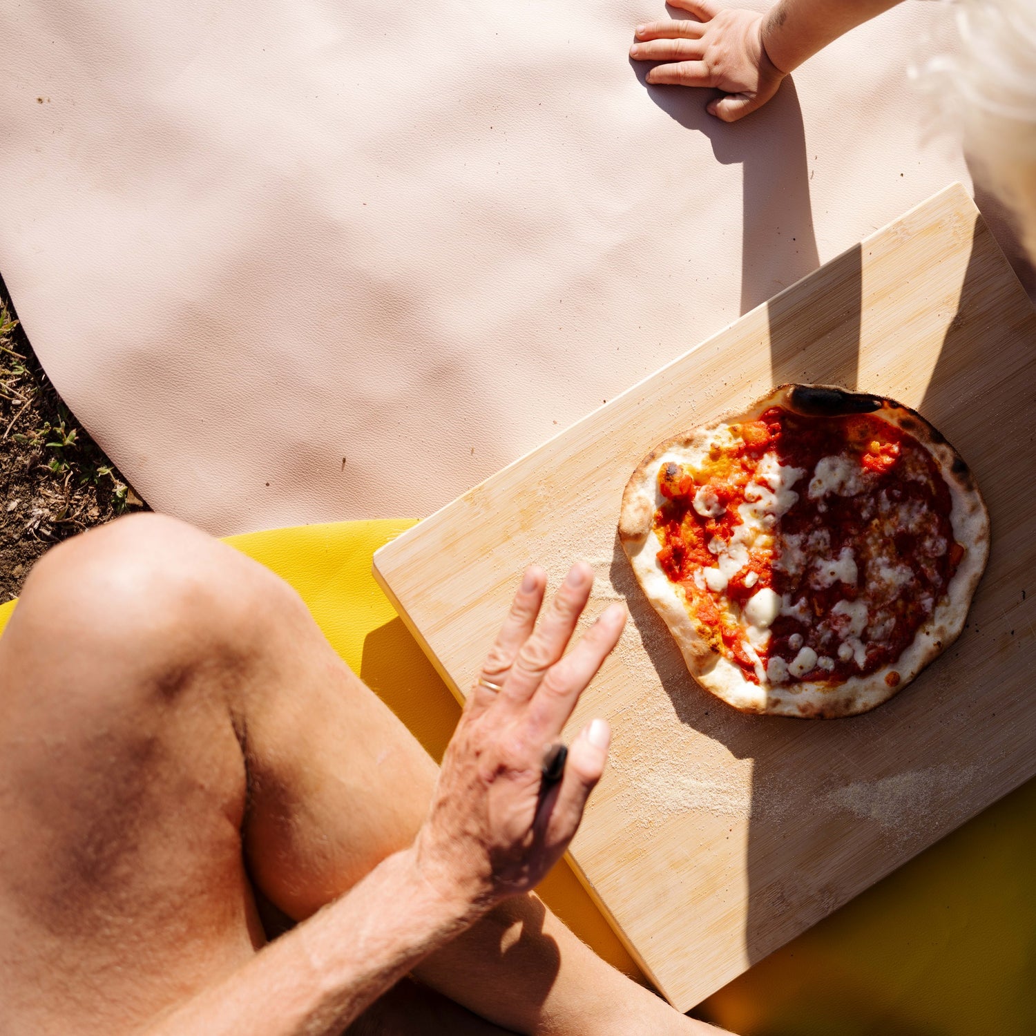 Explore Beige/Wine large round silicone play mat, adult slicing pizza on a board on the mat
