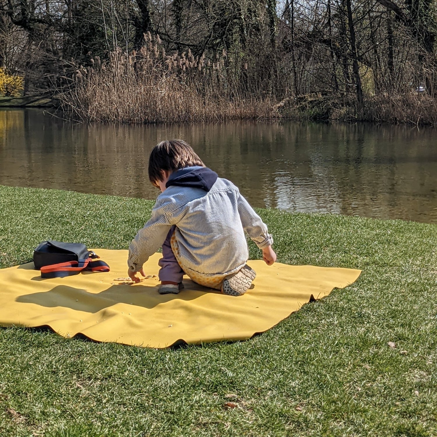 Explore Yellow/Mocca large round silicone play mat, boy yellow mat pond bank bare trees early spring