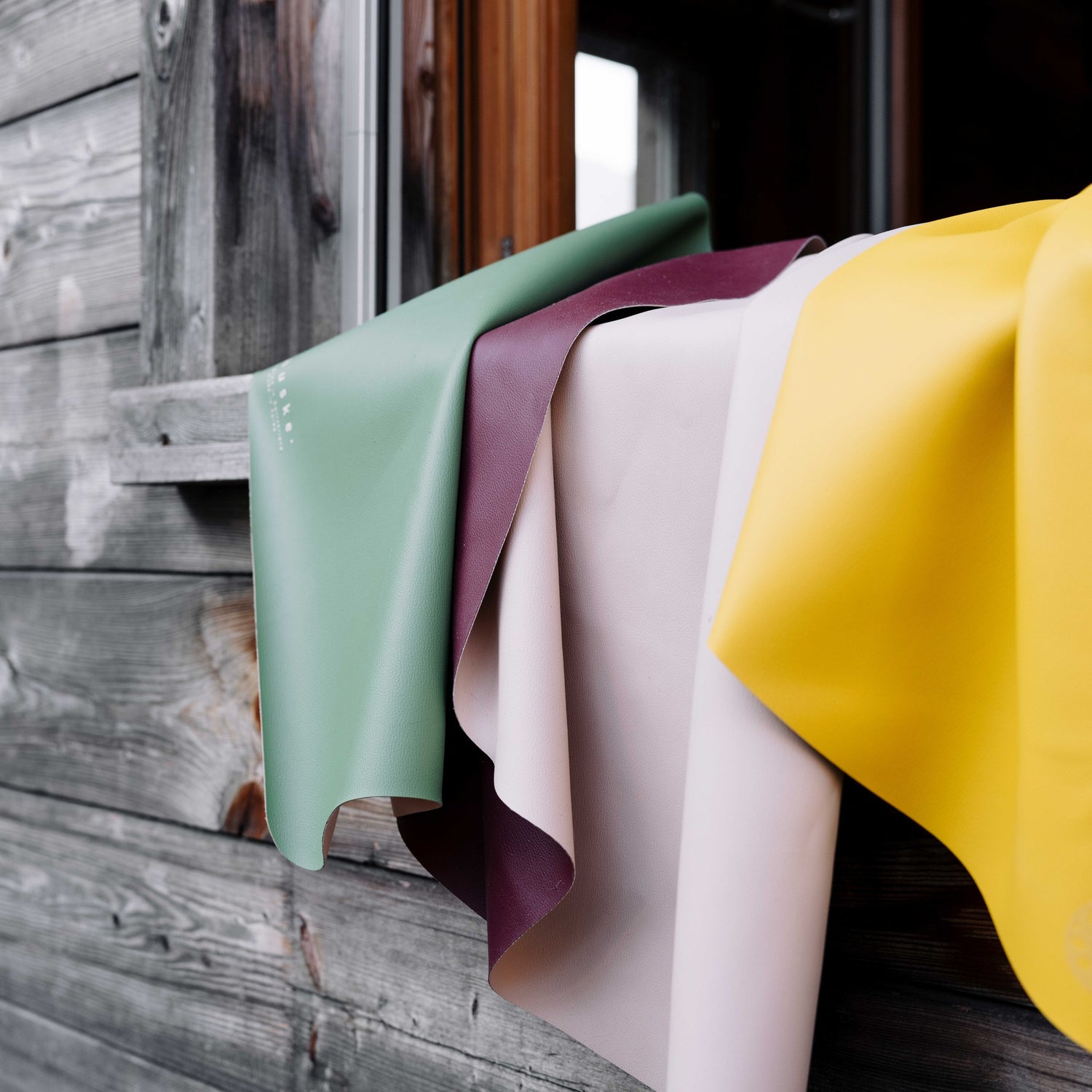 Explore Beige/Wine large round silicone play mat, mats draped over a cabin railing