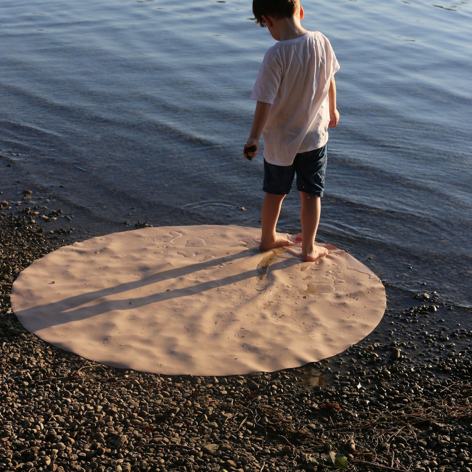 Explore Beige/Wine large round silicone play mat, round beige mat boy standing holding pebble evening