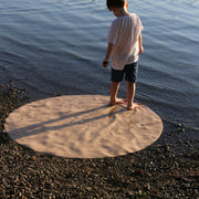 Explore Beige/Wine large round silicone play mat, round beige mat boy standing holding pebble evening