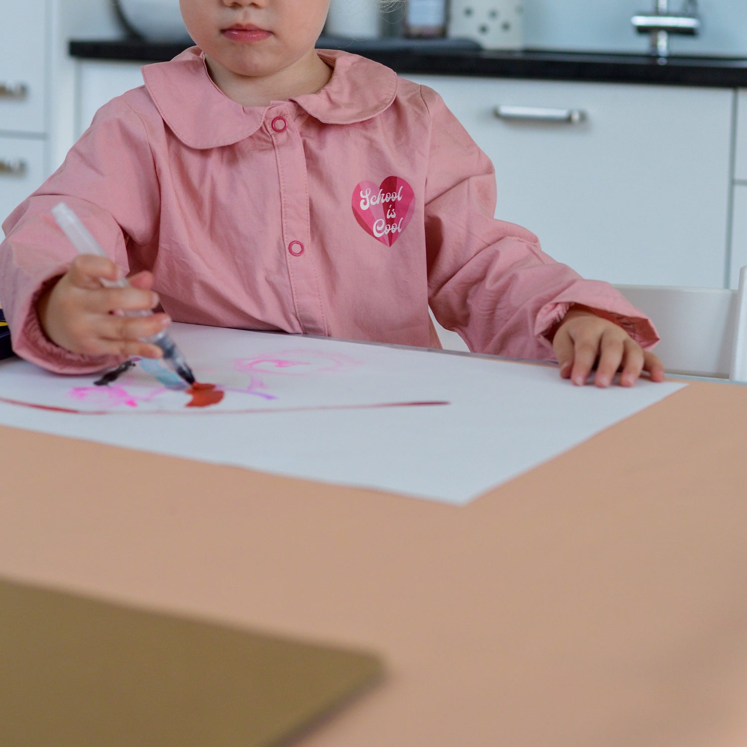 Roam Square Peach/Green silicone craft mat, toddler drawing at the kitchen table