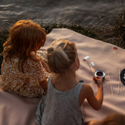 Gallivant XL Silikon-Picknickmatte in Beige/Weinrot, zwei Kinder rösten am Wasser Marshmallows auf der Matte