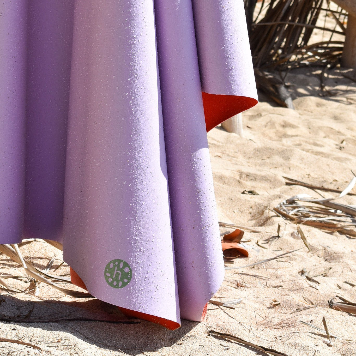 Gallivant XL Lilac/Red silicone family picnic mat, close up detail of lavender huske mat corner with sand and water