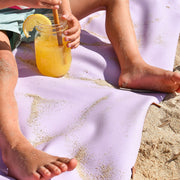 Gallivant XL Lilac/Red silicone family picnic mat, close up of sandy bare feet and legs on lavender huske mat, child's