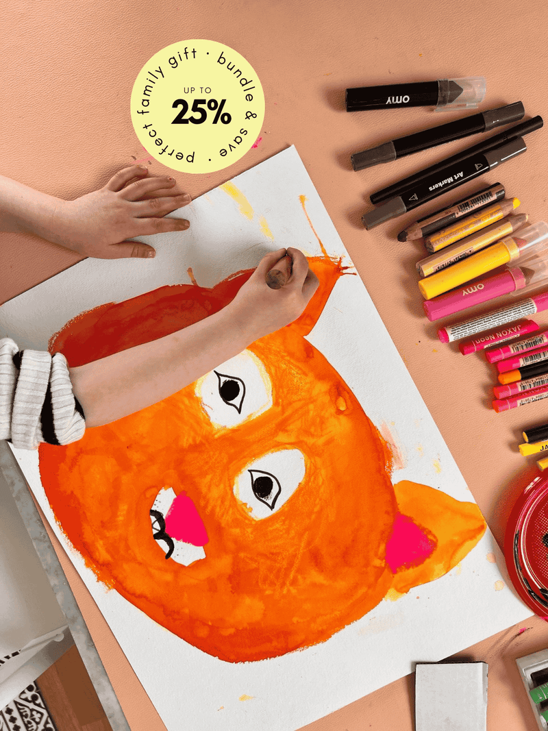 Child painting on Studio Huske mat, close framing shows texture and tools.