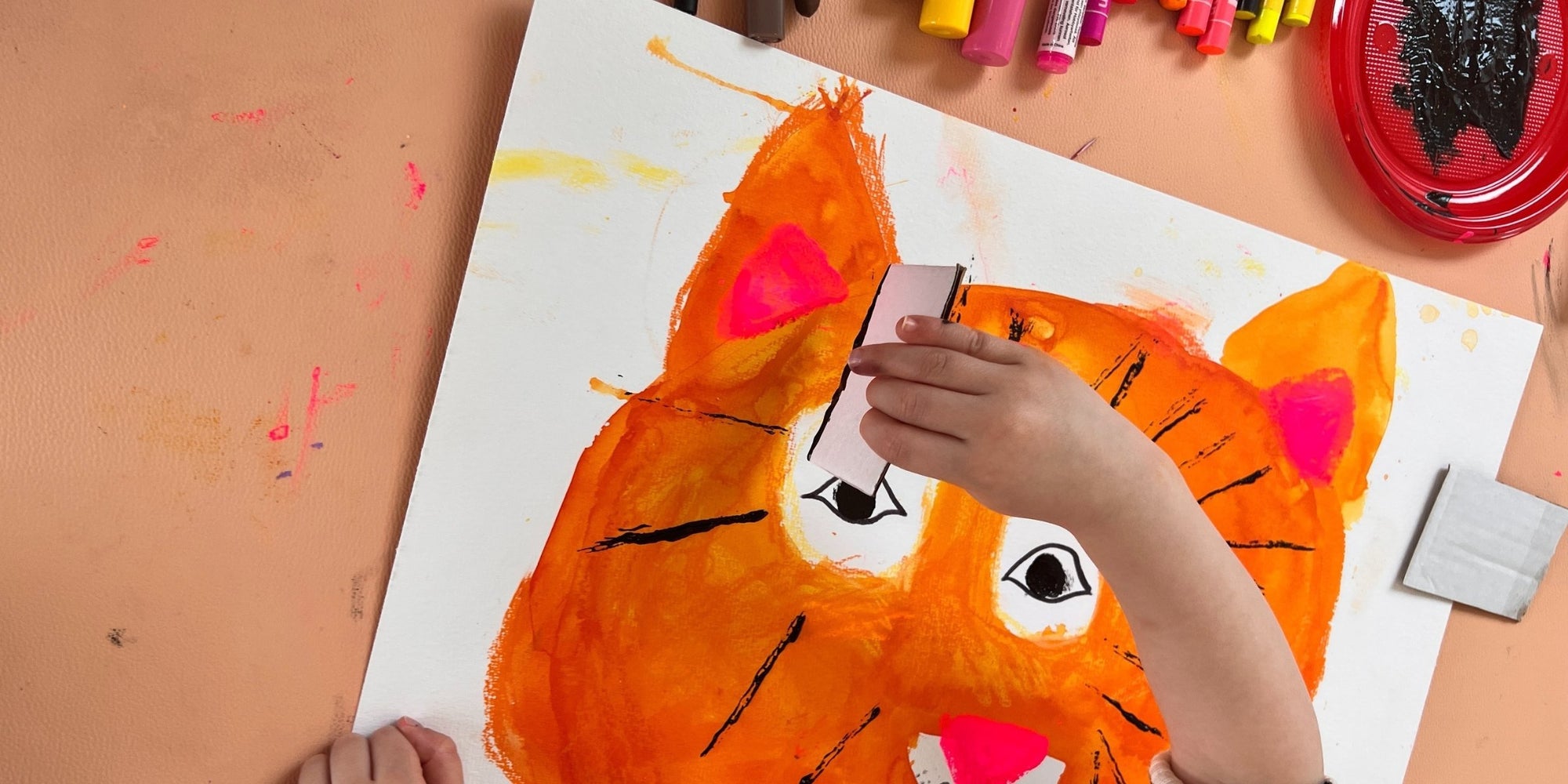 Child painting a tiger on Studio Huske mat in soft indoor light.