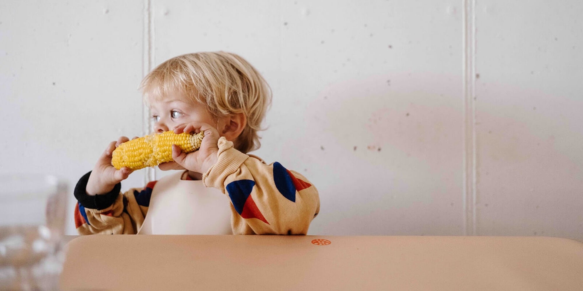 Studio Huske silicone leather mat used under a child’s high chair and on a dining table in natural Swiss light.