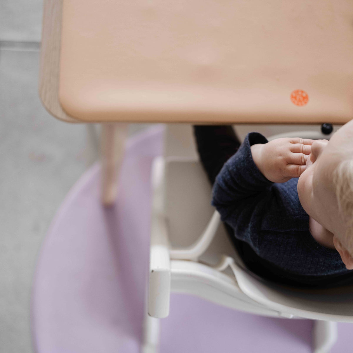 Wriggle Tapis à langer et set de table en silicone pêche/vert, un bébé dans sa chaise haute, le tapis sur la tablette