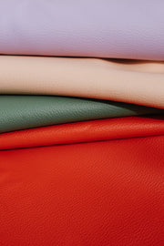 Vegan leather play mat materials in pastel colors, showcasing soft and wipe-clean textures for comfortable play.