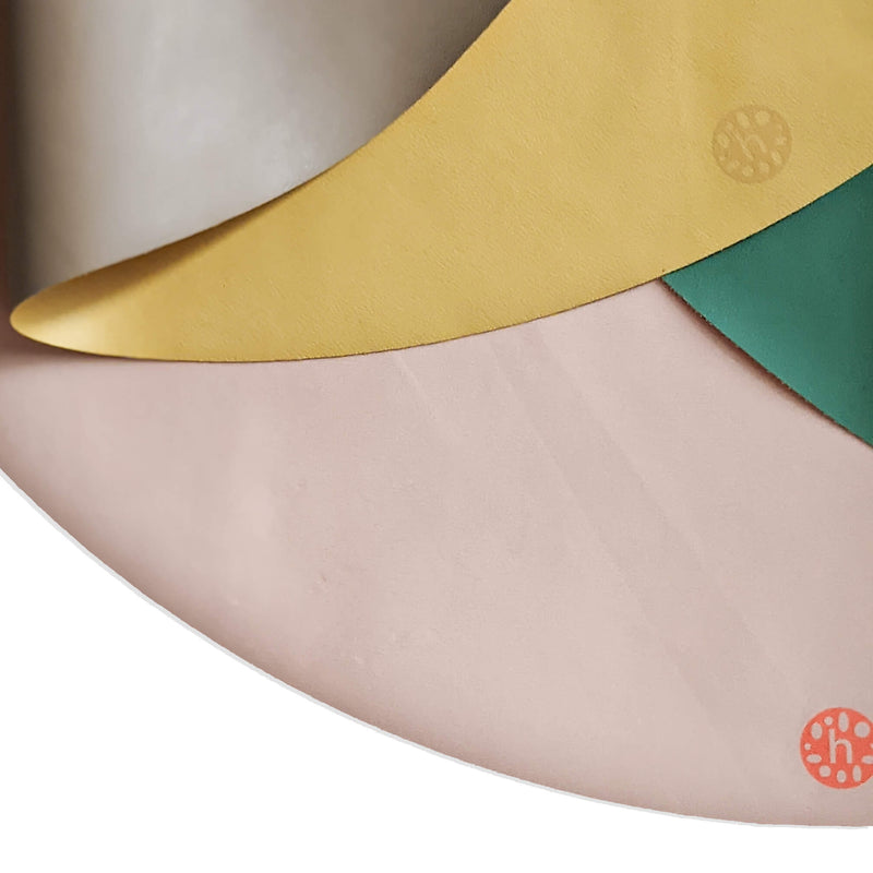 Silicone leather play mat in multiple colors, showcasing the round Roam Mat's design and texture.