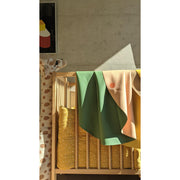 Vegan leather play mat draped over a crib in a modern nursery with soft lighting.