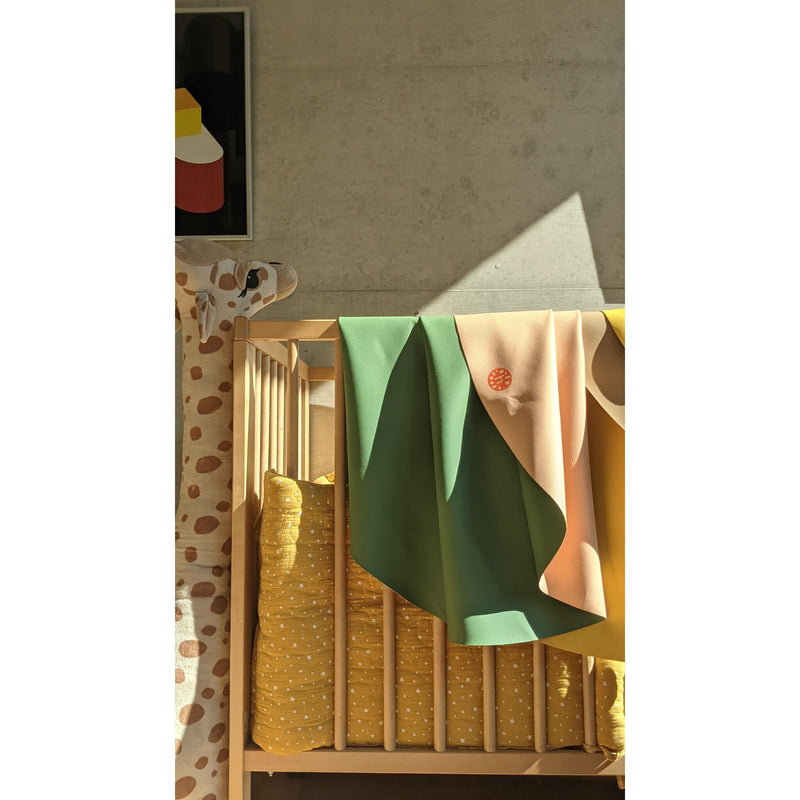 Vegan leather play mat draped over a crib in a modern nursery with soft lighting.