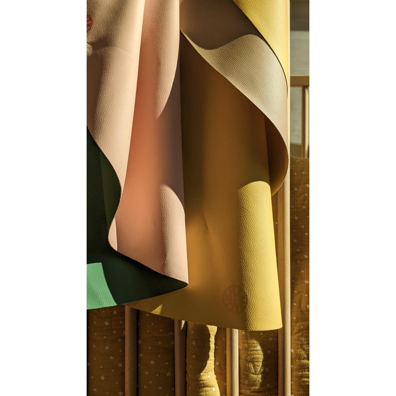 Silicone leather play mat in soft, minimal colors hanging elegantly, ideal for family spaces.