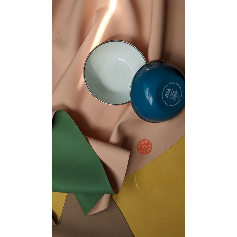 Vegan leather play mat with colorful bowls and soft materials for a creative play space.