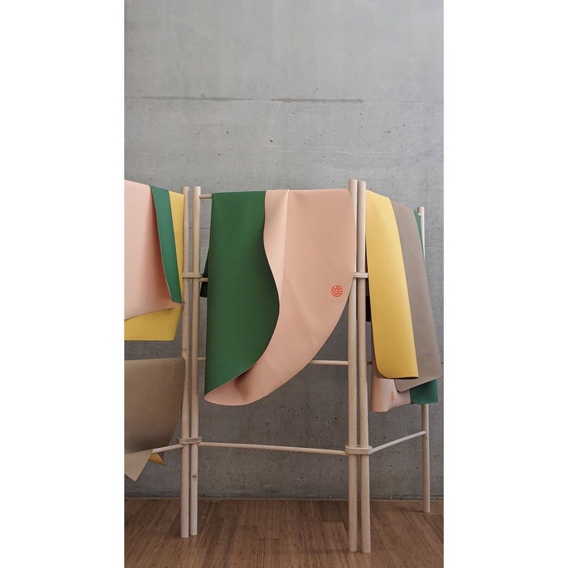 Silicone leather play mat displayed on a rack, showcasing soft, minimal colors for children's play areas.