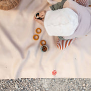 A child playing with colorful rings on an extra large waterproof silicone mat, Gallivant Mat (XL) outdoors.