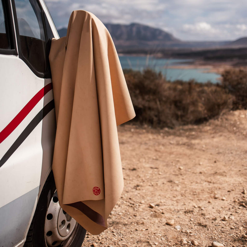 Extra large waterproof silicone mat draped over a vehicle near a scenic outdoor landscape.