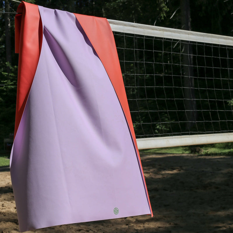 Extra large waterproof silicone mat, Gallivant Mat (XL) hanging on a volleyball net in natural setting.