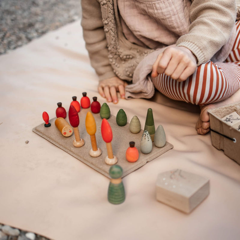 Child playing with colorful wooden toys on an extra large waterproof silicone mat, Gallivant Mat (XL).