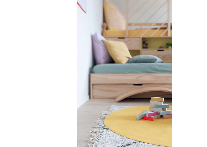 Ikea Kura bed hack DIY plans with colorful rug and building blocks in a bright children's room.