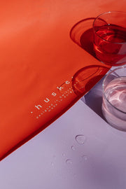 Large round waterproof play mat with glasses of water on a colorful surface.