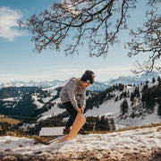 A boy playing with a waterproof silicone leather changing mat in a snowy mountain landscape.