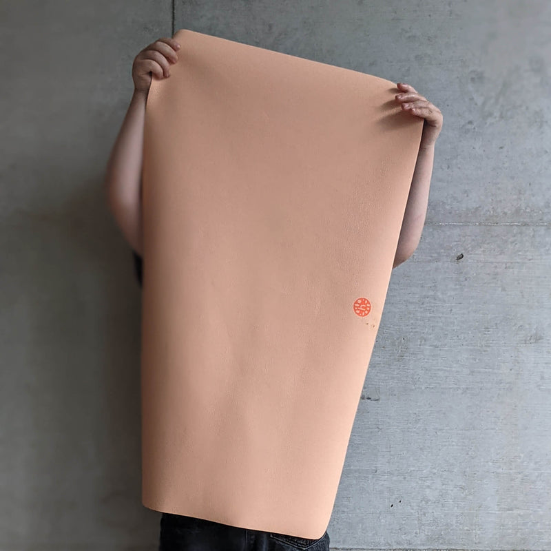 Waterproof silicone leather changing mat, Wriggle Mat (S) held up to showcase its premium surface and design.