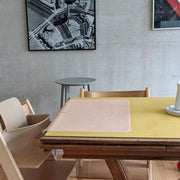 Waterproof silicone leather changing mat on a yellow table, showcasing a minimalist design for easy cleaning and use.