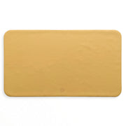 Waterproof silicone leather changing mat, Wriggle Mat (S) in a warm yellow color, perfect for changing and play.