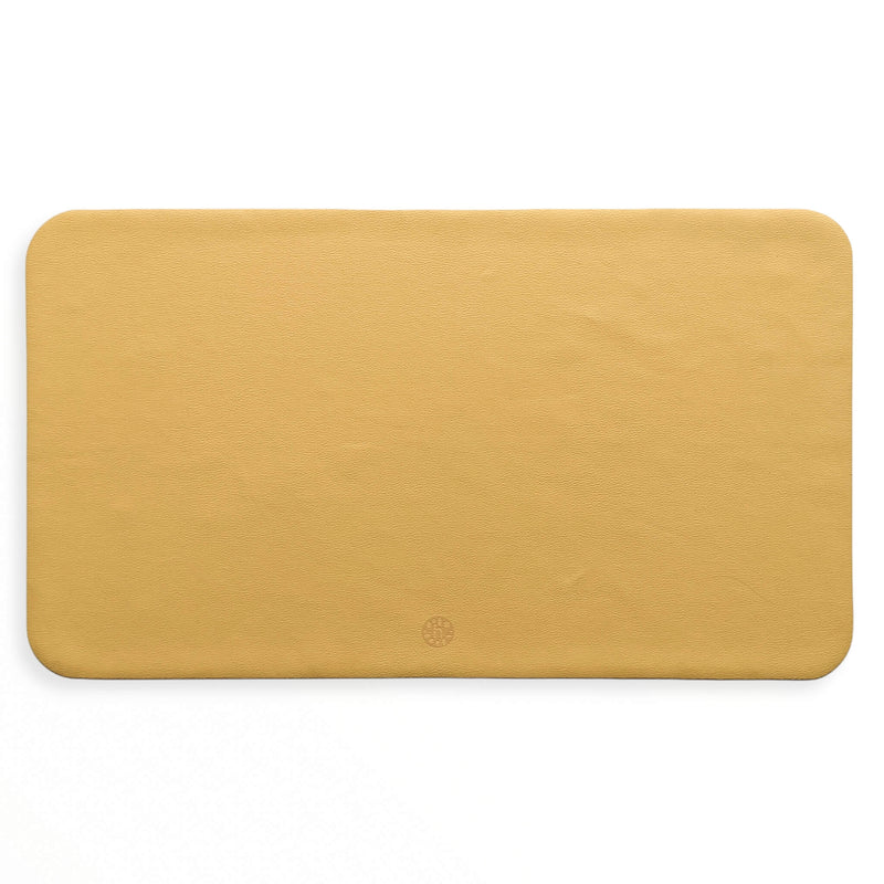 Waterproof silicone leather changing mat, Wriggle Mat (S) in a warm yellow color, perfect for changing and play.