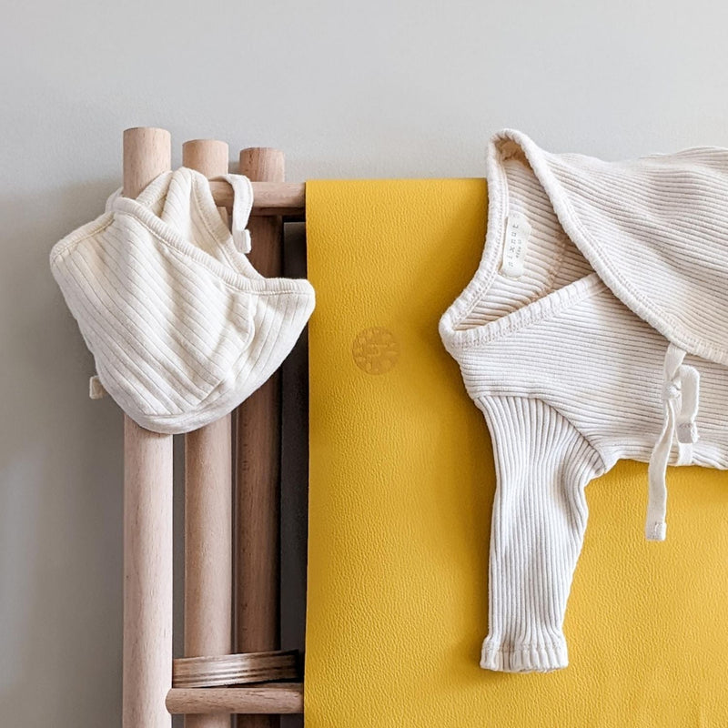 Waterproof silicone leather changing mat with baby clothing, showcasing a compact and tactile design.