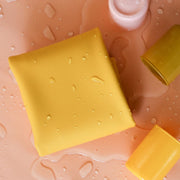 Waterproof silicone leather changing mat in yellow with drops of water, ideal for changing and play.