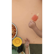 Waterproof square play mat for children with a child holding a popsicle and a bowl of pasta.