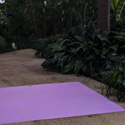 Waterproof square play mat for children, Roam Mat in a natural setting surrounded by greenery.